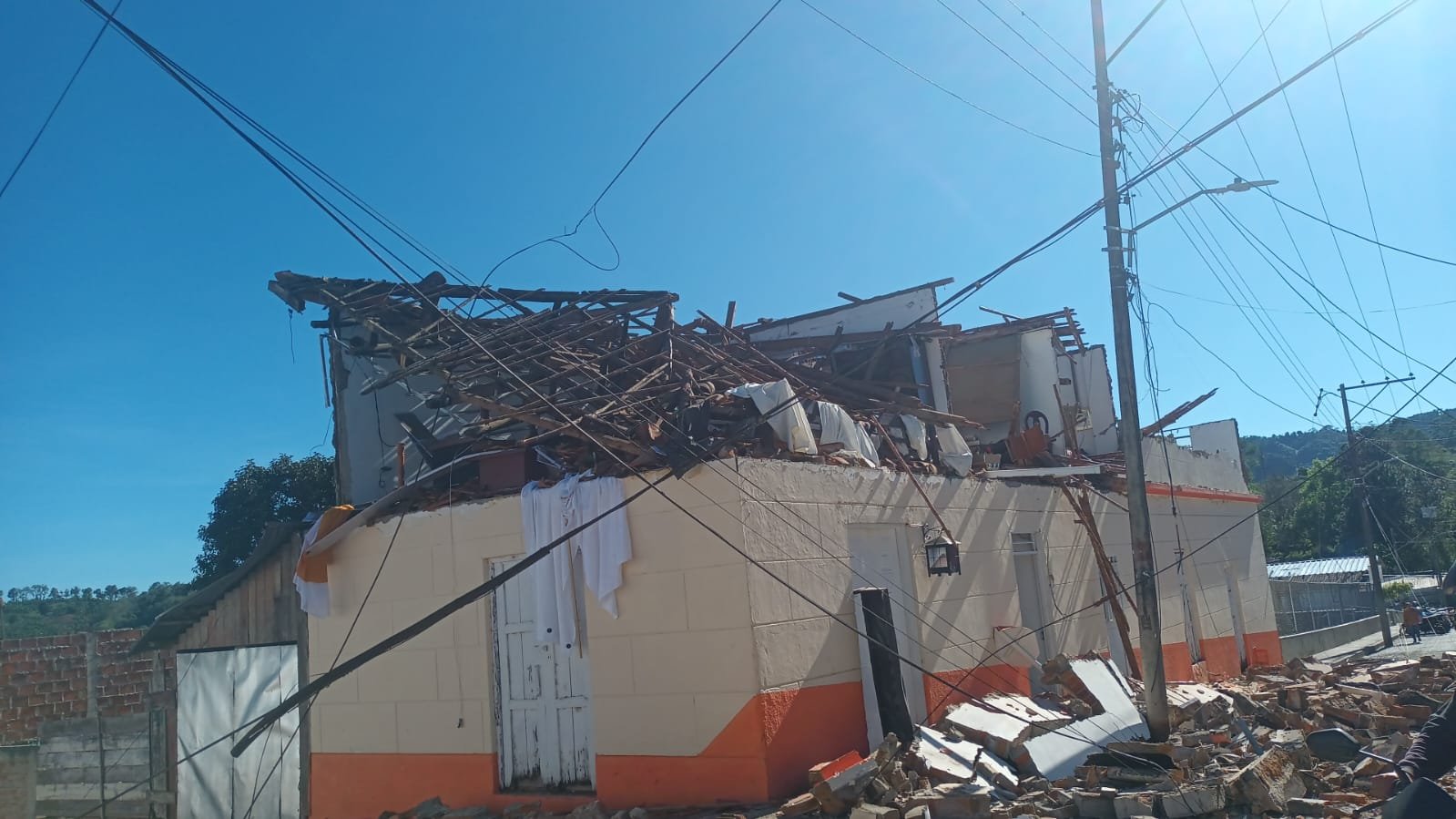 Casa de esquina en Versalles con el segundo piso derrumbado y cables de luz caídos sobre la calle